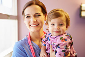 a young woman smiling and holding a baby girl