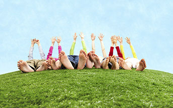 people laying down on a grass hill